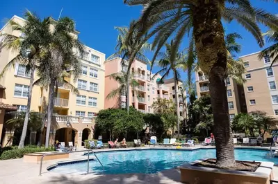 a swimming pool with palm trees and buildings at Luxe 3BR Apartment with Great Patio at Yacht Club in Aventura