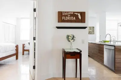 a kitchen with a sink and a table in a room at Luxe 3BR Apartment with Great Patio at Yacht Club in Aventura