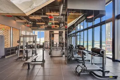 a gym with several tread machines and large windows at 4604 Lux Miami Studio City and Bay Views in Miami