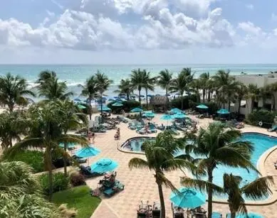 an aerial view of a resort with a pool and palm trees at Condo w/2 Queen beds & Ocean View | Tides in Hollywood
