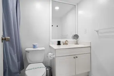 a bathroom with a toilet and a sink and a mirror at Condo w/2 Queen beds & Ocean View | Tides in Hollywood
