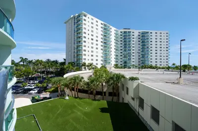 an apartment building with a lawn in front of a building at Condo w/2 Queen beds & Ocean View | Tides in Hollywood