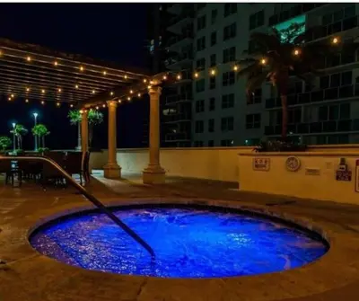 a pool of blue water in a courtyard at night at Comfortable apartment in Downtown Miami in Miami