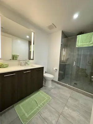 a bathroom with a toilet and a glass shower at Comfortable apartment in Downtown Miami in Miami