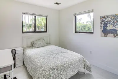 a white bedroom with a bed and two windows at 5 Mi to Beach Group Getaway with Yard in Miami in Miami