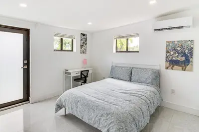 a white bedroom with a bed and a desk at 5 Mi to Beach Group Getaway with Yard in Miami in Miami