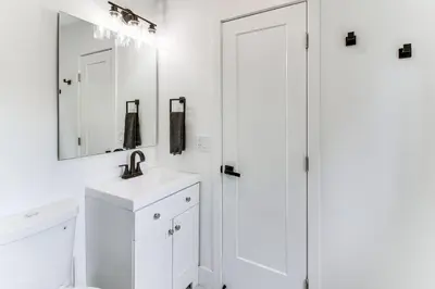 a white bathroom with a sink and a mirror at 5 Mi to Beach Group Getaway with Yard in Miami in Miami