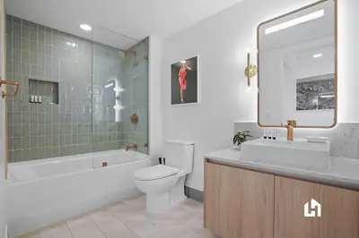 a bathroom with a toilet and a sink and a mirror at Stylish Sky-High Condo with Pool and Gym in Miami