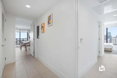 a white hallway with a view of a living room at Stylish Sky-High Condo with Pool and Gym in Miami