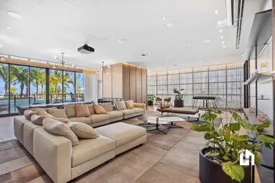 a living room with a large couch and a table at Stylish Sky-High Condo with Pool and Gym in Miami