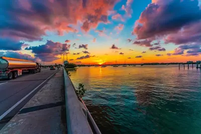 a sunset over a body of water with a truck at TROPICAL Villa with POOL in Private Island in Miami Beach