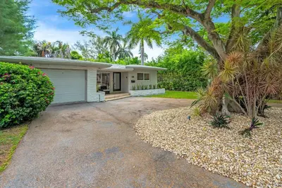 a white house with a tree and a driveway at TROPICAL Villa with POOL in Private Island in Miami Beach
