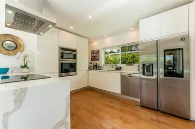a kitchen with white cabinets and stainless steel appliances at TROPICAL Villa with POOL in Private Island in Miami Beach