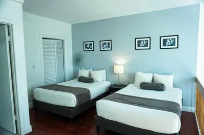 two beds in a room with blue walls at Shine Suites Duplex Bay7A in Miami Beach