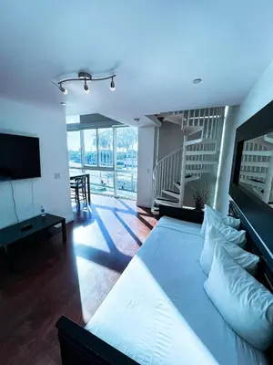a bedroom with a large bed and a living room at Shine Suites Duplex Bay7A in Miami Beach