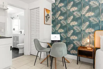 a bathroom with a table and two chairs and a laptop at Byron Avenue Suites in Miami Beach
