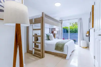 a white bedroom with a bunk bed and a lamp at Walk to Coral Gables| Beautiful Property| Sleeps 8 in Miami