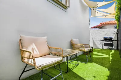 two chairs and a table on a patio with grass at Beachy Living |Sleep 8 Best Location | BBQ & Patio in Miami