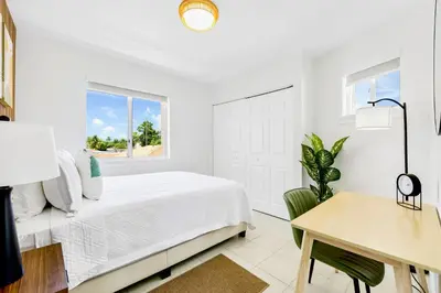 a white bedroom with a bed and a desk at Tropical | 8PPL | Top Location | Parking | Laundry in Miami