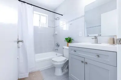 a white bathroom with a toilet and a sink at Marina | Top Location | 8PPL | Parking | Laundry in Miami