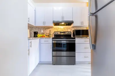 a kitchen with white cabinets and a refrigerator at Marina | Top Location | 8PPL | Parking | Laundry in Miami