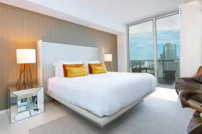 a bedroom with a white bed and a large window at Relaxing Beach Escape with Scenic Views in Hollywood