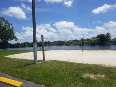 a volleyball court next to a body of water at 1161 Efficency Miami-Lakes in Tamiami