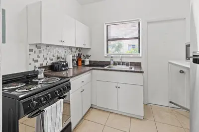 a white kitchen with a stove and a sink at Stay in Brickell near Kaseya Center & South Beach in Miami