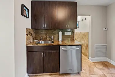 a kitchen with wooden cabinets and a sink at Prime Location – Walkable to Wilton Drive in Fort Lauderdale