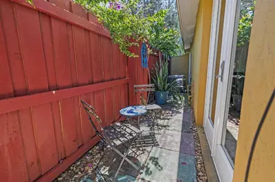 a patio with two chairs and a table next to a fence at Prime Location – Walkable to Wilton Drive in Fort Lauderdale