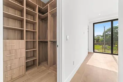 an empty walk in closet with wooden shelves at Jungle Serene Lux Home with Pool Sauna Ice Bath in Fort Lauderdale