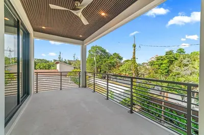 a balcony with a ceiling fan and a view of trees at Jungle Serene Lux Home with Pool Sauna Ice Bath in Fort Lauderdale