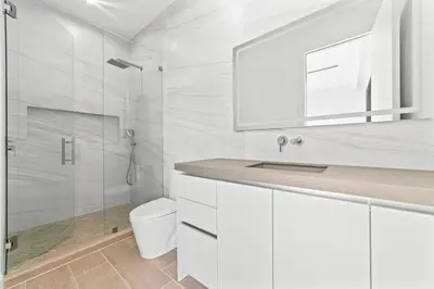 a white bathroom with a shower and a toilet at Jungle Serene Lux Home with Pool Sauna Ice Bath in Fort Lauderdale