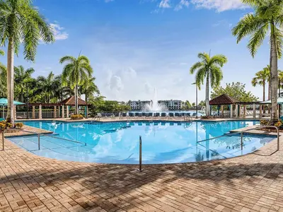 a large swimming pool with palm trees and a fountain at Marriott's Villas at Doral 2BR Apartment with Resort Access in Miami