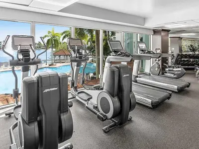 a gym with several tread machines and a swimming pool at Marriott's Villas at Doral 2BR Apartment with Resort Access in Miami