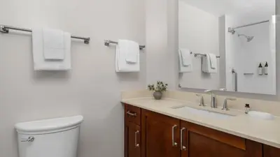 a bathroom with a toilet and a sink and a mirror at Marriott's BeachPlace Towers 2BR Apartment with Resort Access in Fort Lauderdale