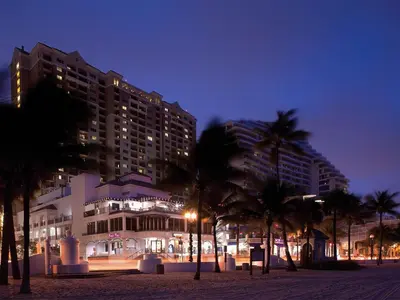 a large building with palm trees in front of it at Marriott's BeachPlace Towers 2BR Apartment with Resort Access in Fort Lauderdale
