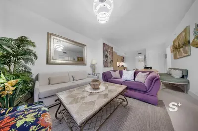 a living room with two purple couches and a table at Chic 2-Bedroom Downtown Condo with Breathtaking City & Waterfront Views in Miami