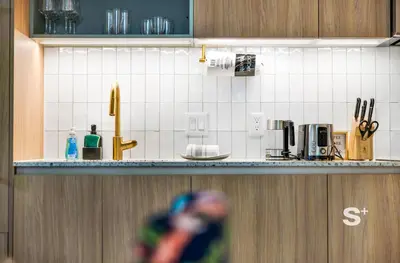 a kitchen with white tiled walls and a counter at Chic 2-Bedroom Downtown Condo with Breathtaking City & Waterfront Views in Miami
