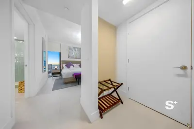 a white room with a bed and a bedroom at Chic 2-Bedroom Downtown Condo with Breathtaking City & Waterfront Views in Miami