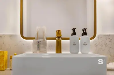 a counter with three bottles of soap and a mirror at Sleek 3-BD Downtown Miami Condo with Water & City Views in Miami