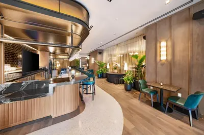 a bar in a hotel lobby with green chairs at Sleek 3-BD Downtown Miami Condo with Water & City Views in Miami