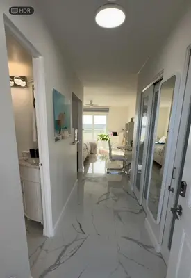 a living room with a hallway with marble tile floors at Beautiful Studio w Amazing View of Miami Skyline in Miami Beach