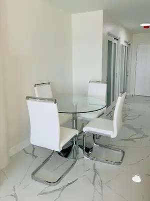 a dining room with a glass table and white chairs at Beautiful Studio w Amazing View of Miami Skyline in Miami Beach