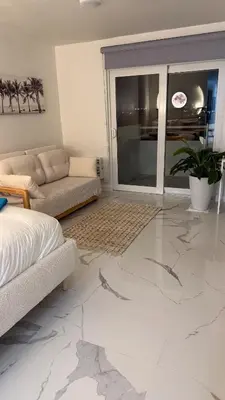 a living room with a large white marble floor at Beautiful Studio w Amazing View of Miami Skyline in Miami Beach