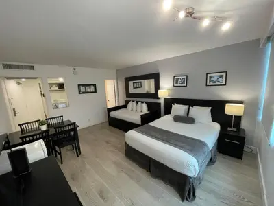 a hotel room with a bed and a desk and a room at Shine Suites Studio 8 in Miami Beach