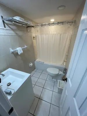 a white bathroom with a toilet and a sink at Shine Suites Studio 8 in Miami Beach