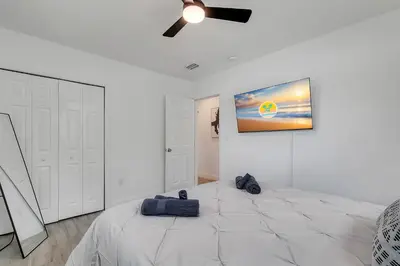 a bedroom with a large bed with a tv on the wall at Hope Casa Heated Pool and BBQ 4bedrooms 2baths by HostyMosty in Hollywood