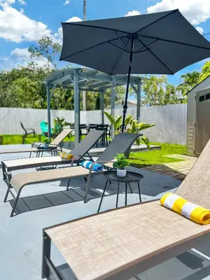 a group of tables and chairs with an umbrella at Hope Casa Heated Pool and BBQ 4bedrooms 2baths by HostyMosty in Hollywood