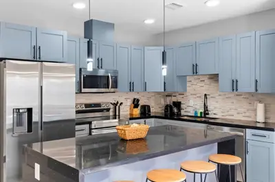 a kitchen with white cabinets and a counter with stools at Family-Friendly Apt in Miami - Sleeps 4, Near Everything in Miami